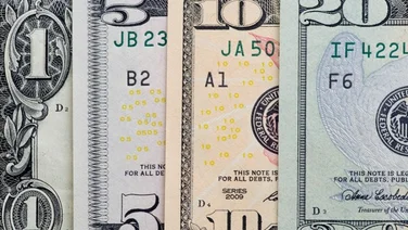 a one dollar bill next to a $5, $10 and $20