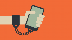 Phone chained to hand orange background iOS 12 Screen Time
