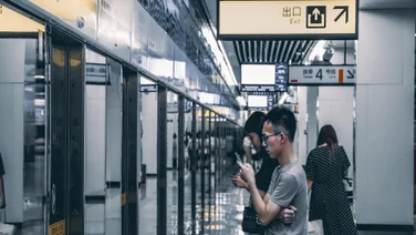 man using phone in chinese train station