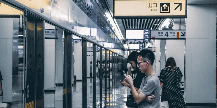 man using phone in chinese train station