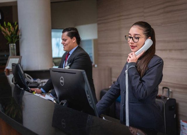 hotel receptionist with phone