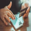 person using phone with credit card