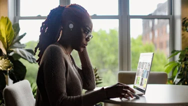 A woman with a laptop on a table in her home office