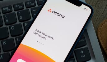 Asana app on a phone over a laptop