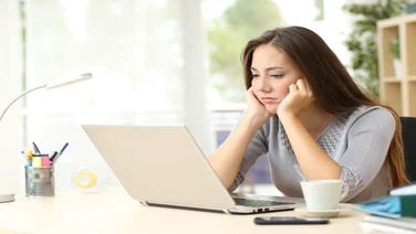 Remote worker looking bored staring at laptop screen