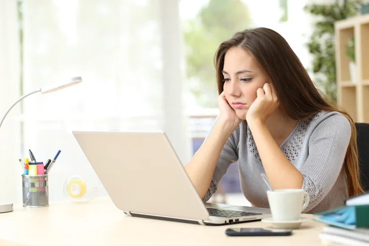 Remote worker looking bored staring at laptop screen