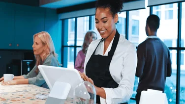 A woman in a cafe uses a POS machine. Source: Tech.co