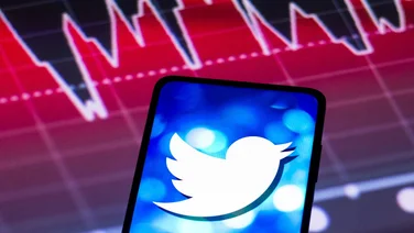 Twitter logo on phone above graph