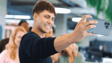 A person takes a selfie for their work's social media account.
