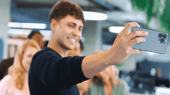 A person takes a selfie for their work's social media account.