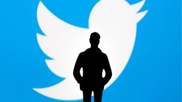 Elon Musk stood in front of Twitter logo