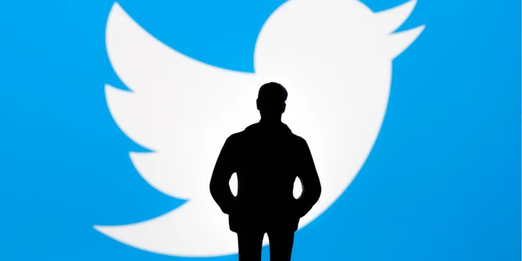 Elon Musk stood in front of Twitter logo