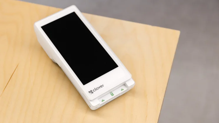 White Clover handheld POS device with integrated receipt printer.