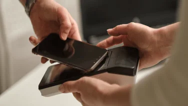 A worker takes payment with a mobile POS device.