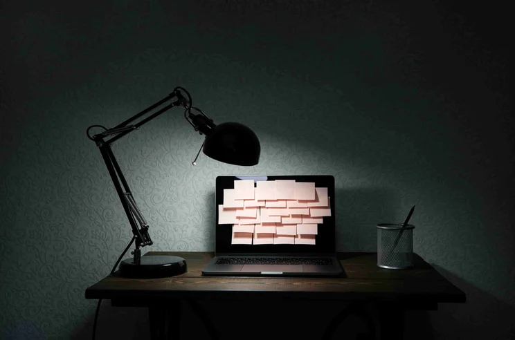 Desk with post it notes on computer screen (email overload)