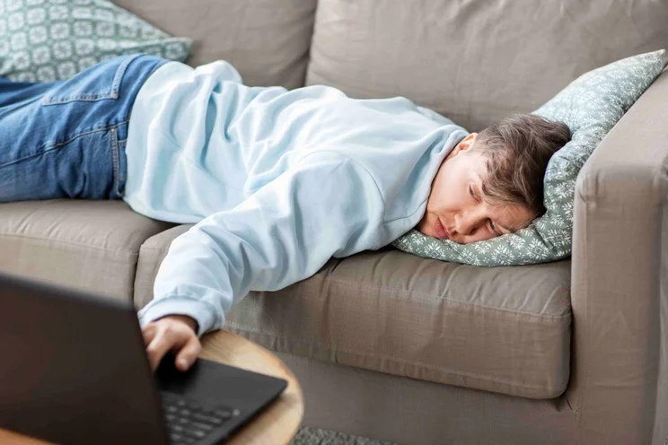 Man on sofa looking at computer
