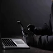 Hacker in gloves with phone