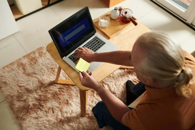Man storing password on post it