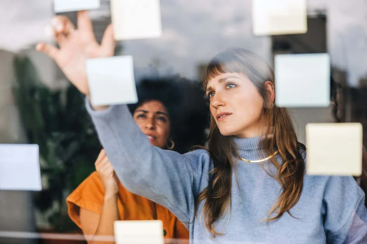 Women looking at post it note