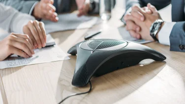 Office workers using a conference phone