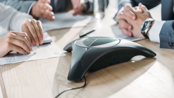 Office workers using a conference phone