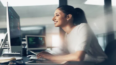 Woman coder smiling at laptop
