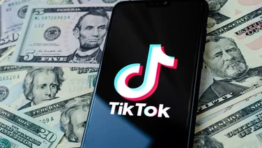 TikTok app on bed of dollars