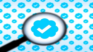 Twitter blue tick under a magnifying glass
