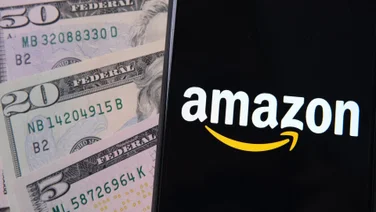 Amazon logo on phone on pile of dollars