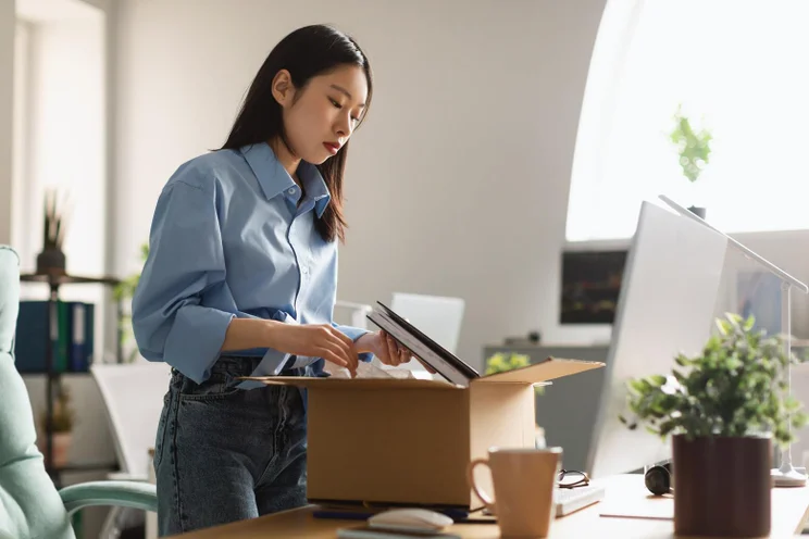 Women packing up her office equipment
