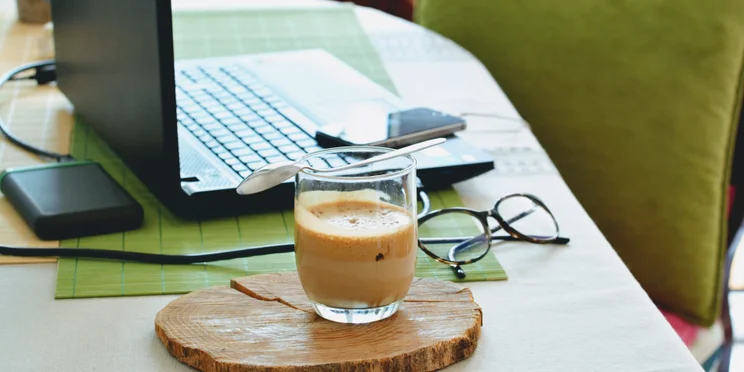 coffee on a table next to a laptop