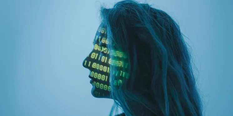 A woman with binary code projected across her face.