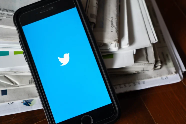Twitter logo on a pile of papers