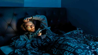 Man on phone in bed