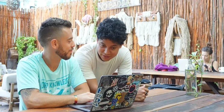 two remote workers in Mexico looking at laptop