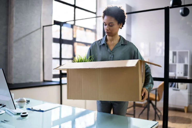 Female laid off employee collecting items