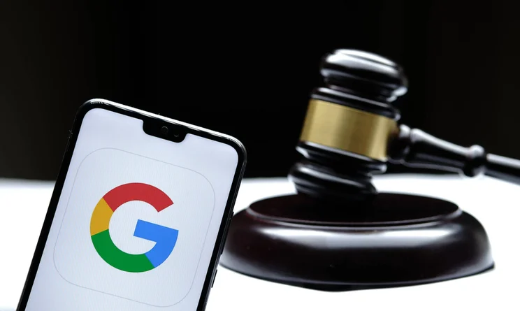 Google logo on phone with gavel behind.