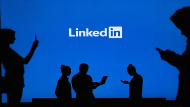 Silhouettes of people on screens in front of LinkedIn logo