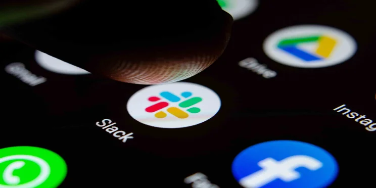 Slack logo on a smartphone screen with finger about to press