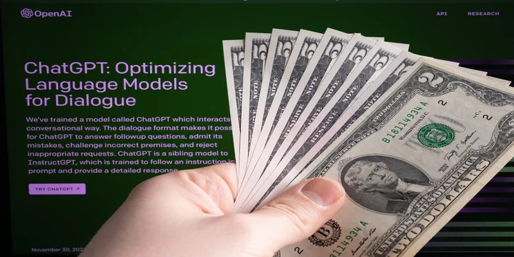 chatgpt login page with hand holding cash