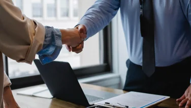 Office workers shake hands since one has paid leave.