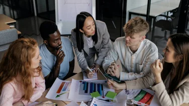 Marketing managers creating SMART objectives around a table.