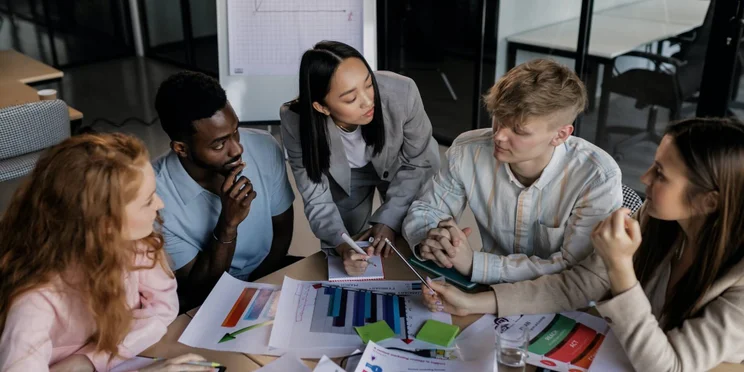 Marketing managers creating SMART objectives around a table.