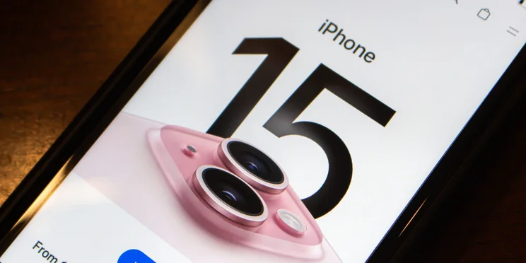 The iPhone 15 website showing on the screen of a smartphone