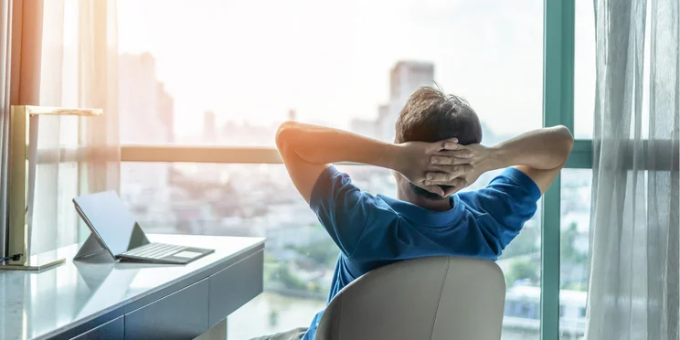 Office worker reclining in a chair at his desk