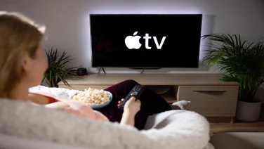Woman watching AppleTV on television