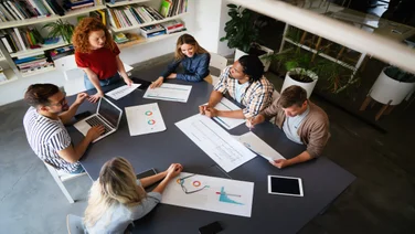 Employees sat round a take in a startup