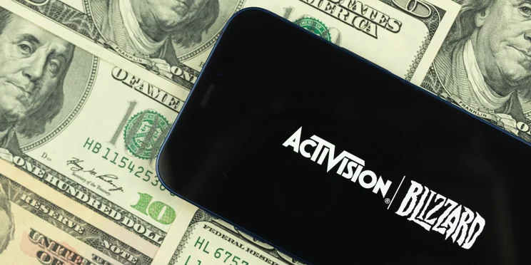 Activision Blizzard logo against piles of dollars