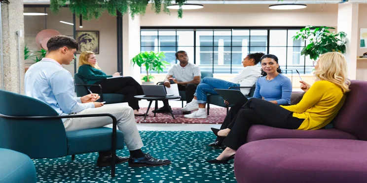 People in office talking. Source: Tech.co