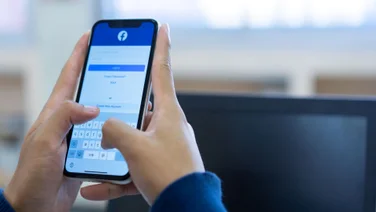 Man trying to log in to Facebook app or website on mobile phone